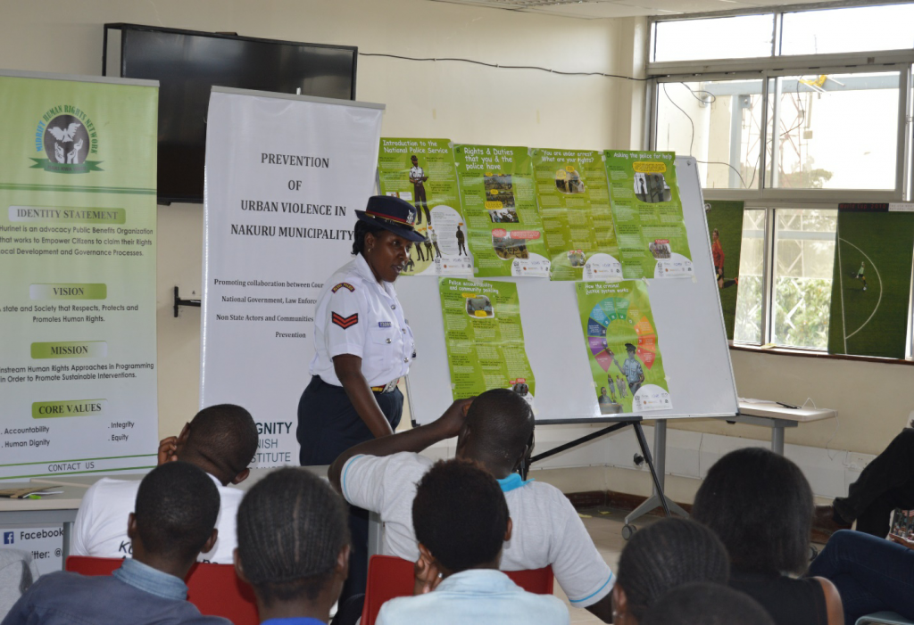 Gender officer from Kaptembwo police station leading discussions on 101 Q&A booklet on police at KNLS Nakuru Library